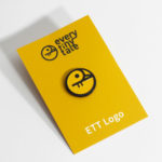 A photo of an everytinytale soft enamel pin, carded.